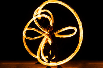 The power to manipulate heat and fire. Couple of dancers manipulate burning pois. Fire performance. Poi twirling. Grace and danger. Night festival