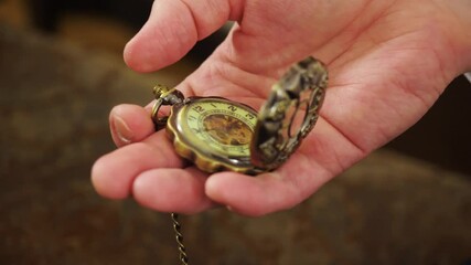 Man holds antique hand watch. Stock footage. Close-up of beautiful hand watch with patterns on lid. Close-up of man looking at vintage hand-held watch