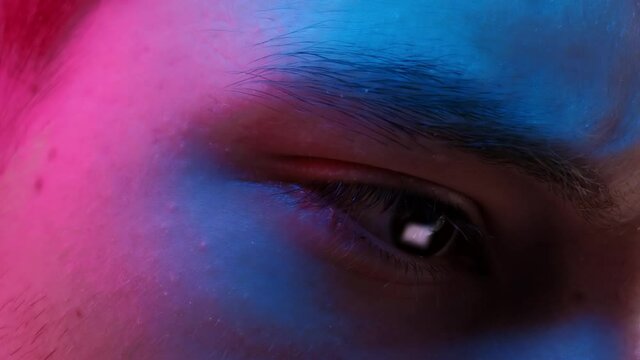 Close up of man eye working on a computer, blue and ping coolers