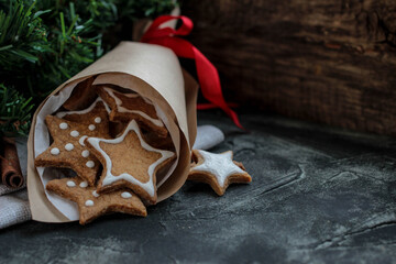 Christmas composition with cookies in paper bag on dark background. Card or banner with copyspace