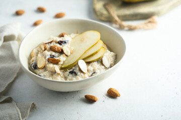 Oatmeal porridge with nuts, raisins and fresh pear
