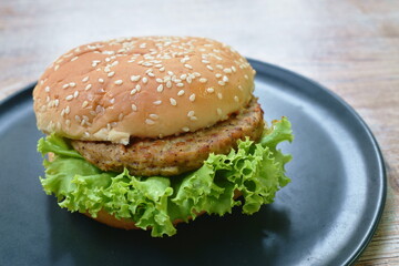 spicy grilled pork cheese hamburger with barbecue sauce and lettuce on plate