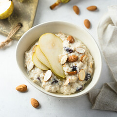 Oatmeal porridge with nuts, raisins and fresh pear