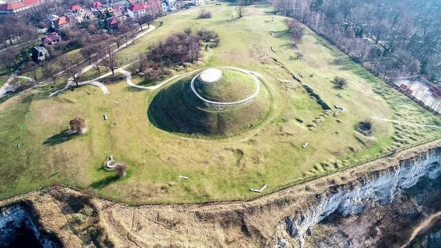 Krakus Mound in Krakow, Poland. The origin of the mound, probably early medieval kurgan, is not known. Old quarry in front. City panorama in the background. Aerial 4K video.