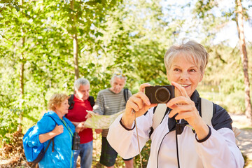 Seniorin mit Fotoapparat auf einer Wanderung