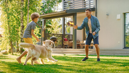 Handsome Father and Son Spend Quality Family Time Together, Play Soccer with Football, Passing to Each other, and Having Fun. Sunny Day Idyllic Suburban Home Backyard with Loyal Golden Retriever Dog 