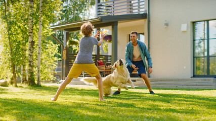 Handsome Father and Son Play Catch With Loyal Family Friend Golden Retriever Dog. Family Spending Time Together Training Dog. Sunny Day Idyllic Suburban Home Backyard. © Gorodenkoff