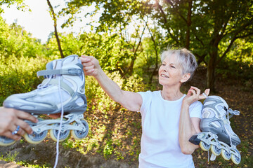 Vitale Seniorin mit Inline Skates in der Natur