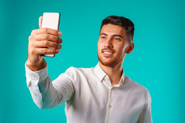 Young businessman in white shirt taking selfie on his smartphone