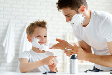 Obraz na płótnie Canvas Father teaches his little son how to shave face