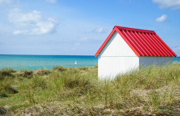 Beach hut in the dunes. Picturesque colorful wooden beach cabin at Gouville-sur-Mer, Cotentin, Normandy, France