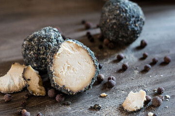 Swiss cheese Belper Knolle in the shape of small balls sprinkled with black pepper. Gourmet appetizer. Selective focus