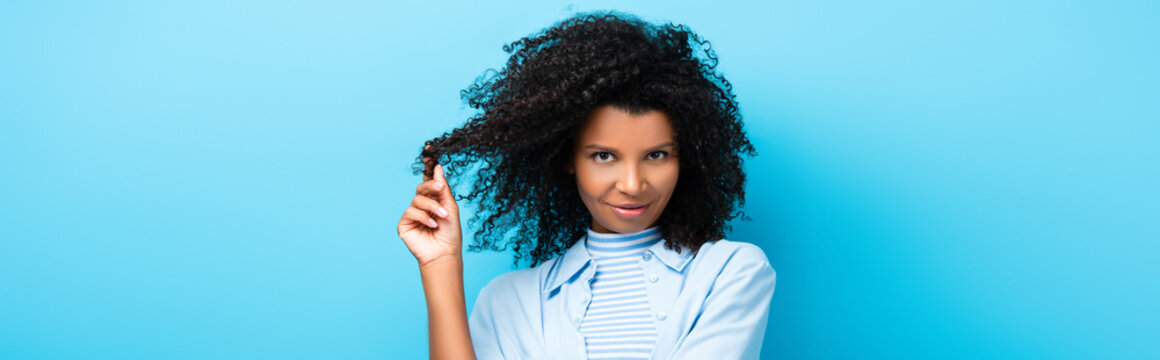 Curly African American Woman Twirling Hair On Finger On Blue, Banner