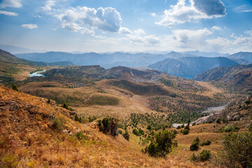 Rocky pass with mountain top views and lakes in high mountains. Young men and women hiking near Sary Chelek lake, Sary-Chelek Jalal Abad region, Kyrgyzstan, Trekking in Central Asia.