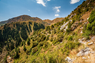 Rocky pass with mountain top views in high mountains. Young men and women hiking near Sary Chelek...