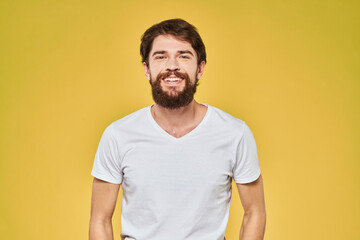 Man gesturing with hands emotions lifestyle white t-shirt yellow isolated background