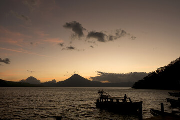 Fototapeta na wymiar Guatemala, Central America: sunset with boats at lake Atitlán (Atitlan) with volcanos Atitlan, Toliman, San Pedro
