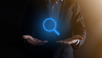 Businessman, man hold in hand magnifying glass icon.business, technology and internet concept
