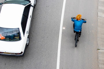 Overhead shot of  a cyclist being overtaken by a car on the road between Bogota and La Calera on the mountains in Colombia - obrazy, fototapety, plakaty