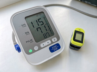 Included tonometer monitor with normal blood pressure readings and pulse oximeter on white background
