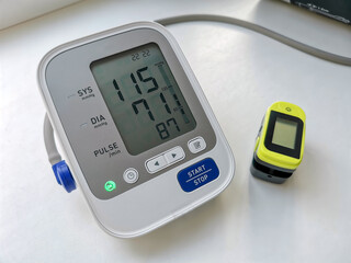 Included tonometer monitor with normal blood pressure readings and pulse oximeter on white...