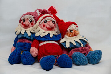 Three self made crocheted colorful gnomes with white background