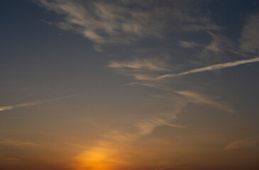 Naklejka na ściany i meble Dawn sky with clouds and contrails