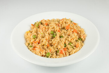 Natural rice with vegetables, risotto on the plate. White background.
