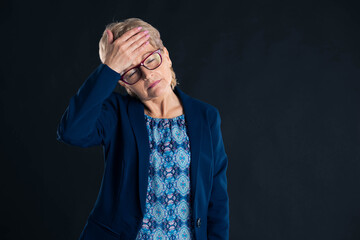 Portrait of an older businesswoman having a headache