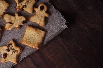 Healthy homemade gluten-free, lactose-free cookies of various shapes without sugar with raisins and chocolate on a dark brown wooden background