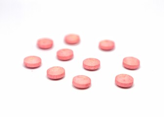 red or pink  round pills isolated on white