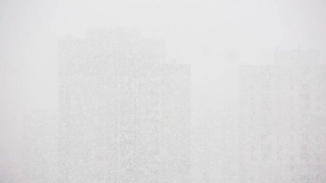 View of tall buildings in the snow. You can hardly see the buildings.