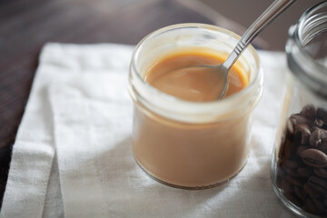Coffee-flavored yogurt pudding dessert in glass jar close-up. Healthy lifestyle, superfood