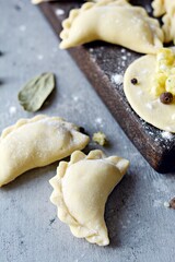 Dumplings with potatoes with herbs on a blue background. Varenyky, vareniki, pierogi, pyrohy - dumplings with filling.
