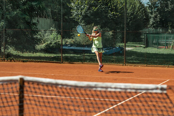 Active senior Caucasian woman in sportswear playing tennis 