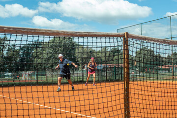 Active senior Caucasian couple in sportswear playing tennis