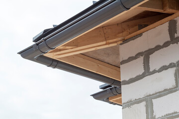 Fototapeta premium close up view of house under construction with holders for gutters water drainage system