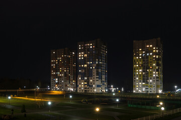 Fototapeta na wymiar Night panorama of Light in the windows of a multistory building. life in a big city