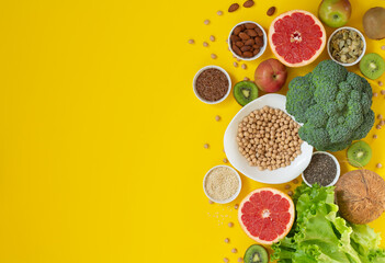 Healthy food selection with fruits, vegetables, seeds, superfood, nuts on yellow background