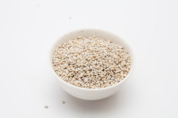 Unhulled barley in white bowl on white background 