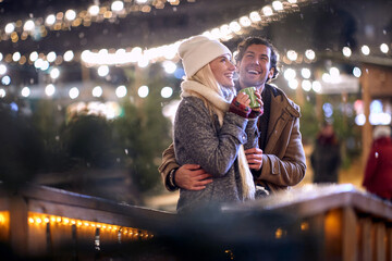 young couple in love enjoying the first snow, smiling. christmastime concept