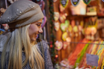 portrait of caucasian blonde with hat on watching colorful shop window