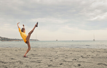 Fototapeta na wymiar young woman dancing at the beach