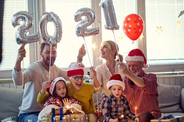Happy family looking forward presents at New Year eve. New Year, holiday, family time together