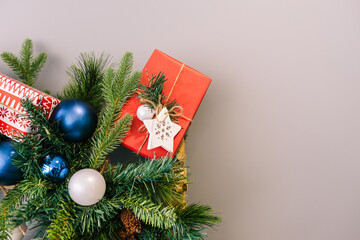 Christmas composition with a spruce branch, Christmas decorations, balls, pine cones and gifts. New Year concept with copy space. Flat lay, top view