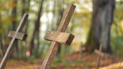 Old Wooden Crucifix on Forgotten Grave in Cemetery Deep in the Woods
