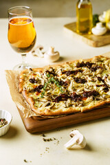 Homemade Belgian style mushroom pizza, flammekeuche, glass of beer on wooden board