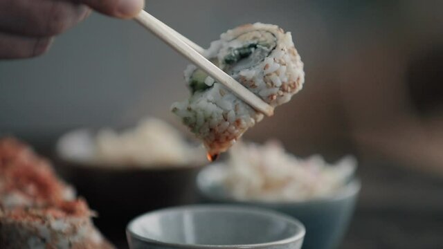 Elle mange des sushis au restaurant.