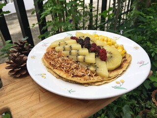 Coconut vanilla pancake with kiwi fruits and roast coconut