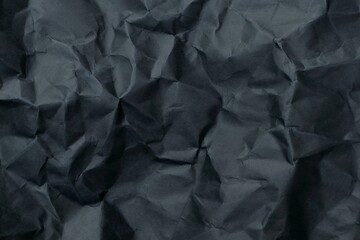 Black crumpled paper textured background.